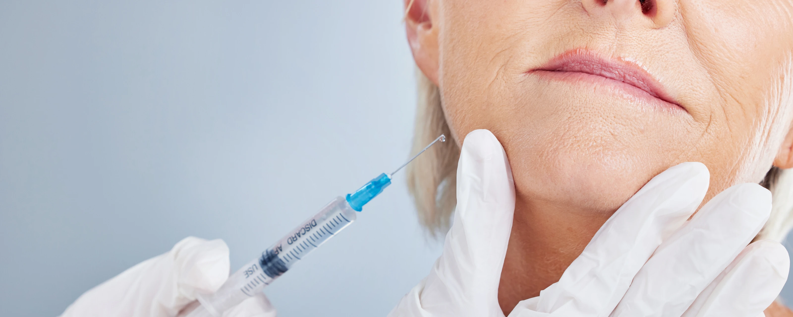 An older woman is receiving a Botox injection